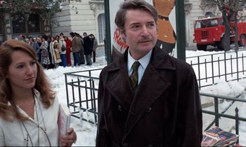 Movie still from “Day for Night” (1973), directed by François Truffaut – A man in a brown coat and tie standing in front of a crowd of onlookers; Medium shot, Low angle