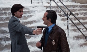 Movie still from “Day for Night” (1973), directed by François Truffaut – A man and a woman holding a gun in the snow; Medium shot, Low angle