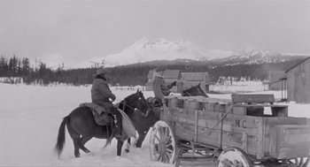 Movie still from “Day of the Outlaw” (1959), directed by André De Toth – Two men on horses pulling a wagon filled with wood; Wide shot, Low angle