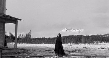 Movie still from “Day of the Outlaw” (1959), directed by André De Toth – A woman in a black cloak standing in the snow; Extreme Wide shot, Low angle