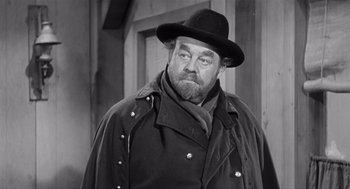 Movie still from “Day of the Outlaw” (1959), directed by André De Toth – An older man with a beard wearing a hat and a jacket; Medium shot, Over the shoulder angle