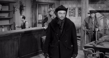 Movie still from “Day of the Outlaw” (1959), directed by André De Toth – A black and white photo of a man in a hat; Medium shot, Low angle