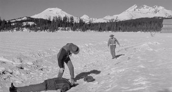 Movie still from “Day of the Outlaw” (1959), directed by André De Toth – Two men in the middle of a snowy field with mountains in the background; Wide shot, High angle