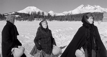 Movie still from “Day of the Outlaw” (1959), directed by André De Toth – A woman in a plaid coat walking in the snow; Medium shot, Low angle