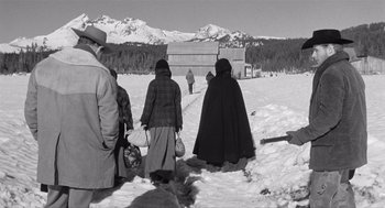 Movie still from “Day of the Outlaw” (1959), directed by André De Toth – A black and white photo of people walking in the snow; Wide shot, Low angle