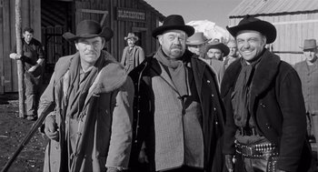 Movie still from “Day of the Outlaw” (1959), directed by André De Toth – A black and white photo of a group of men in hats; Medium shot, Low angle