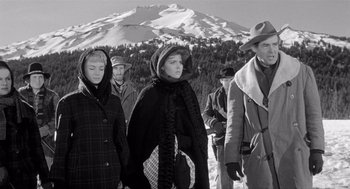 Movie still from “Day of the Outlaw” (1959), directed by André De Toth – A black and white photo of a group of people walking in the snow; Medium shot, Low angle
