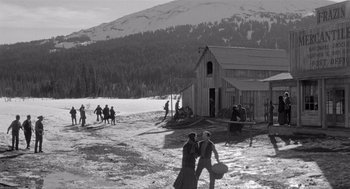 Movie still from “Day of the Outlaw” (1959), directed by André De Toth – A black and white photo of people walking in the snow; Extreme Wide shot, High angle