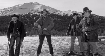 Movie still from “Day of the Outlaw” (1959), directed by André De Toth – A group of men standing on top of a snow covered slope; Wide shot, Low angle