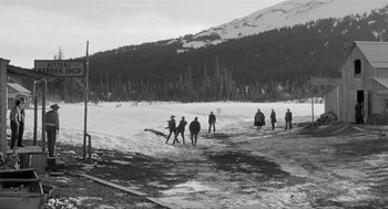 Movie still from “Day of the Outlaw” (1959), directed by André De Toth – A black and white photo of a group of skiers; Extreme Wide shot, High angle