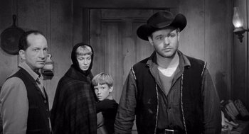 Movie still from “Day of the Outlaw” (1959), directed by André De Toth – A black and white photo of a man and two boys; Medium shot, Low angle