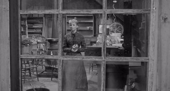 Movie still from “Day of the Outlaw” (1959), directed by André De Toth – An old photo of a woman standing in front of a window; Wide shot, Over the shoulder angle