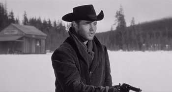 Movie still from “Day of the Outlaw” (1959), directed by André De Toth – A man wearing a cowboy hat while holding a gun; Medium shot, Low angle
