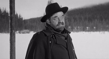 Movie still from “Day of the Outlaw” (1959), directed by André De Toth – An older man wearing a black hat and a black coat; Close Up shot, Low angle