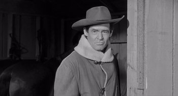 Movie still from “Day of the Outlaw” (1959), directed by André De Toth – Black and white photograph of a man wearing a cowboy hat; Medium shot, Low angle