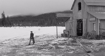 Movie still from “Day of the Outlaw” (1959), directed by André De Toth – A man walking in the snow near a building; Wide shot, Low angle