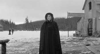 Movie still from “Day of the Outlaw” (1959), directed by André De Toth – A woman in a black cloak standing in the snow; Wide shot, Low angle