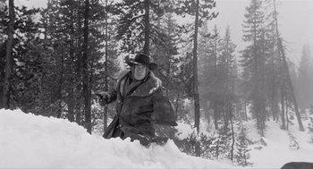 Movie still from “Day of the Outlaw” (1959), directed by André De Toth – A man standing in the middle of a snow covered forest; Wide shot, Low angle