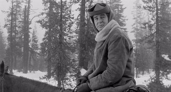 Movie still from “Day of the Outlaw” (1959), directed by André De Toth – A man sitting on top of a horse in the snow; Medium shot, Low angle