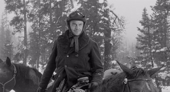 Movie still from “Day of the Outlaw” (1959), directed by André De Toth – A man riding on the back of a horse in the snow; Medium shot, Low angle
