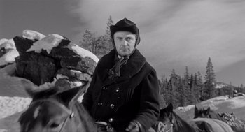 Movie still from “Day of the Outlaw” (1959), directed by André De Toth – A black and white photo of a man on a horse; Medium shot, Low angle