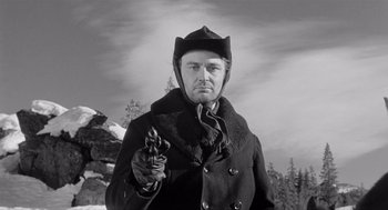 Movie still from “Day of the Outlaw” (1959), directed by André De Toth – A black and white photo of a man holding a gun; Close Up shot, Low angle