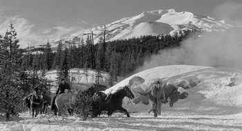 Movie still from “Day of the Outlaw” (1959), directed by André De Toth – A man herds horses through the snow; Wide shot, High angle