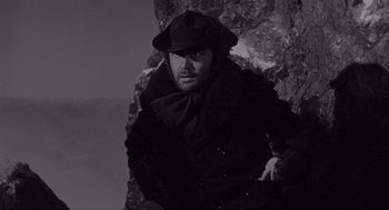 Movie still from “Day of the Outlaw” (1959), directed by André De Toth – A black and white photo of a man in a hat; Medium shot, Low angle