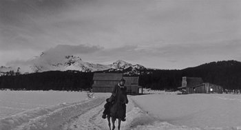 Movie still from “Day of the Outlaw” (1959), directed by André De Toth – A man riding a horse through a snowy field; Wide shot, Low angle
