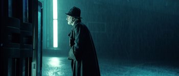 Movie still from “Daybreakers” (2009), directed by Michael Spierig – An old man wearing a hat and a long black coat; Medium shot, Low angle