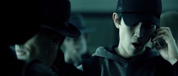 Movie still from “Daybreakers” (2009), directed by Michael Spierig – A man wearing a black hat and a black jacket; Close Up shot, Over the shoulder angle
