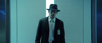 Movie still from “Daybreakers” (2009), directed by Michael Spierig – A man wearing a suit and tie and a hat; Medium shot, Low angle