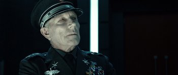 Movie still from “Daybreakers” (2009), directed by Michael Spierig – An older man in a uniform and a hat; Close Up shot, Over the shoulder angle