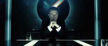 Movie still from “Daybreakers” (2009), directed by Michael Spierig – A man sitting at a table with a cigarette in his mouth; Medium shot, Low angle