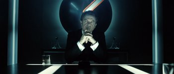 Movie still from “Daybreakers” (2009), directed by Michael Spierig – A man sitting at a table in front of a mirror; Medium shot, Low angle