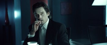 Movie still from “Daybreakers” (2009), directed by Michael Spierig – A man sitting at a table with a cigarette in his mouth; Close Up shot, Over the shoulder angle