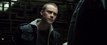 Movie still from “Daybreakers” (2009), directed by Michael Spierig – A man in a black jacket is looking at the camera; Close Up shot, Over the shoulder angle