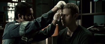 Movie still from “Daybreakers” (2009), directed by Michael Spierig – A man is getting his head shaved by another man; Close Up shot, Over the shoulder angle