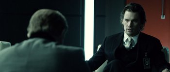 Movie still from “Daybreakers” (2009), directed by Michael Spierig – Two people sitting in front of a window in a dark room; Close Up shot, Over the shoulder angle