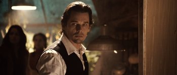 Movie still from “Daybreakers” (2009), directed by Michael Spierig – A person wearing a shirt and vest; Close Up shot, Over the shoulder angle