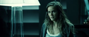 Movie still from “Daybreakers” (2009), directed by Michael Spierig – A woman with long brown hair standing in a dark room; Close Up shot, Over the shoulder angle