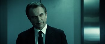Movie still from “Daybreakers” (2009), directed by Michael Spierig – A person wearing a suit and tie; Close Up shot, Over the shoulder angle