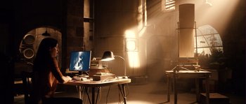 Movie still from “Daybreakers” (2009), directed by Michael Spierig – A computer on a desk in a room with a lamp; Wide shot, High angle