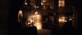 Movie still from “Daybreakers” (2009), directed by Michael Spierig – A man sitting on top of a barrel in a room; Extreme Wide shot, High angle
