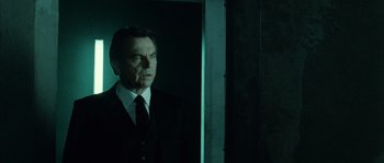 Movie still from “Daybreakers” (2009), directed by Michael Spierig – A man wearing a suit and tie standing in front of a window; Medium shot, Low angle