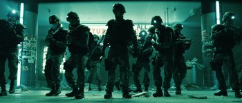 Movie still from “Daybreakers” (2009), directed by Michael Spierig – A group of men standing next to each other in a room; Wide shot, Low angle
