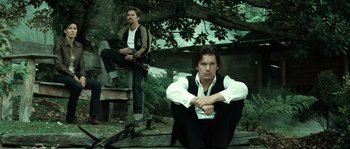 Movie still from “Daybreakers” (2009), directed by Michael Spierig – Two men sitting on a bench in front of a tree; Medium shot, Low angle