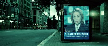 Movie still from “Daybreakers” (2009), directed by Michael Spierig – An advertisement on a bus stop near a street; Extreme Close Up shot, Over the shoulder angle