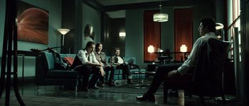 Movie still from “Daybreakers” (2009), directed by Michael Spierig – A group of people sitting in a living room next to each other; Wide shot, Low angle