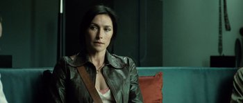 Movie still from “Daybreakers” (2009), directed by Michael Spierig – A woman sitting on top of a couch wearing a leather jacket; Close Up shot, Over the shoulder angle